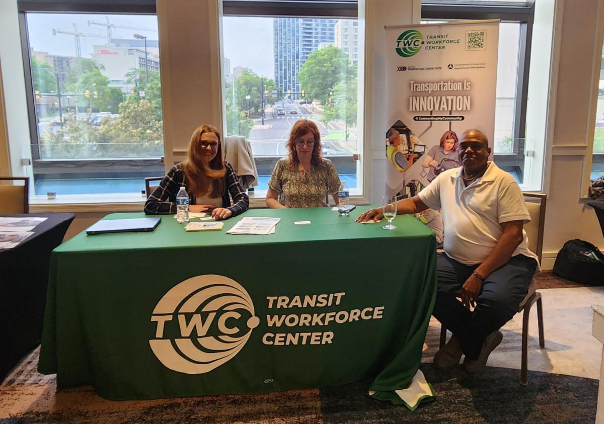 Kristen Ribaudo, Annmarie Carmody, and Frank Burnett sitting at a TWC table at YouthBuild's event