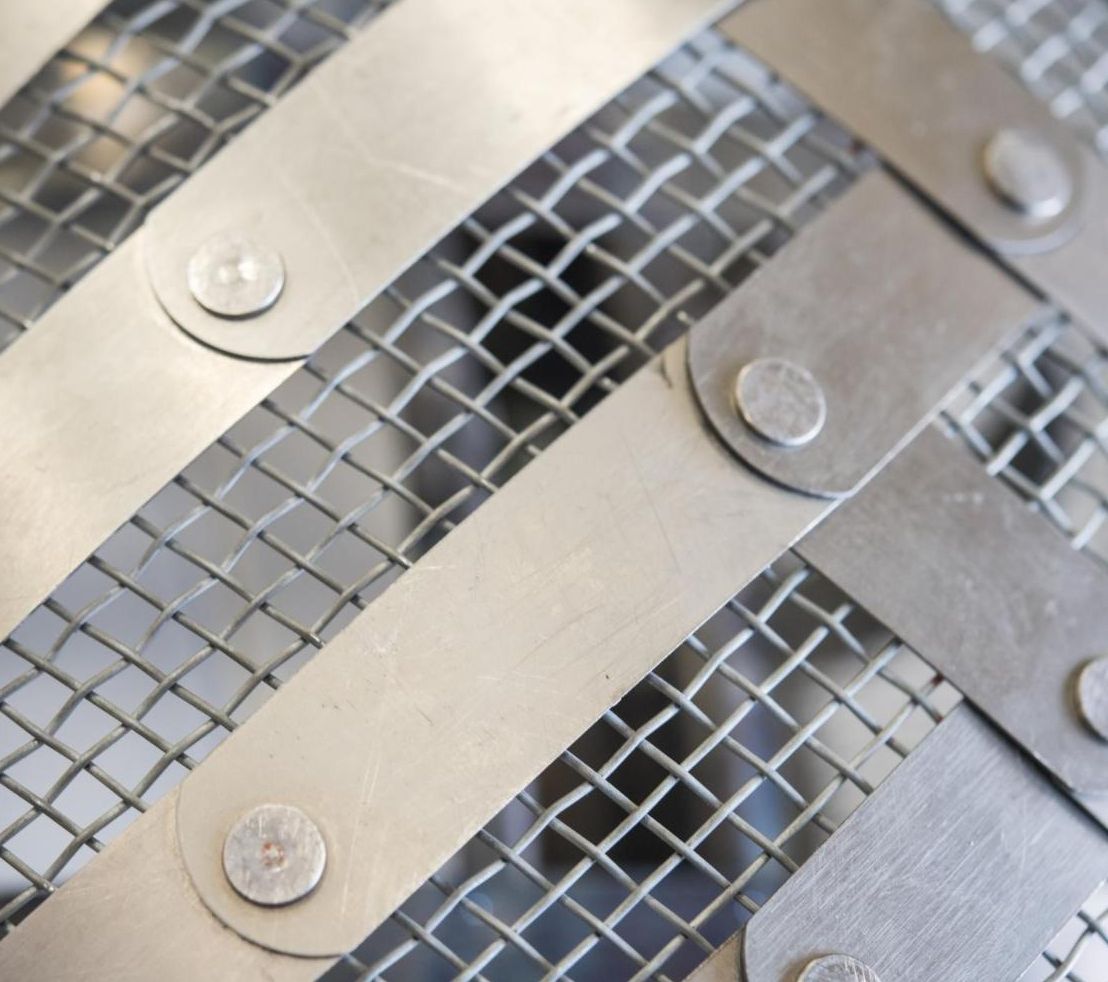 Closeup of an item composed of a metal latticework overlaying a mesh.