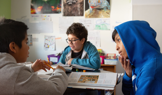 three students working together in a classroom