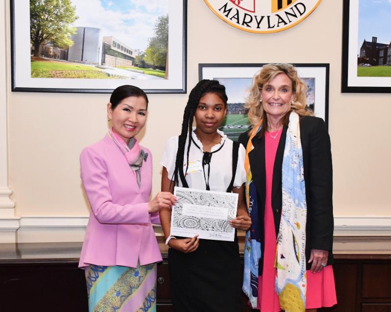 First Lady stands with artist as she accepts citation. 