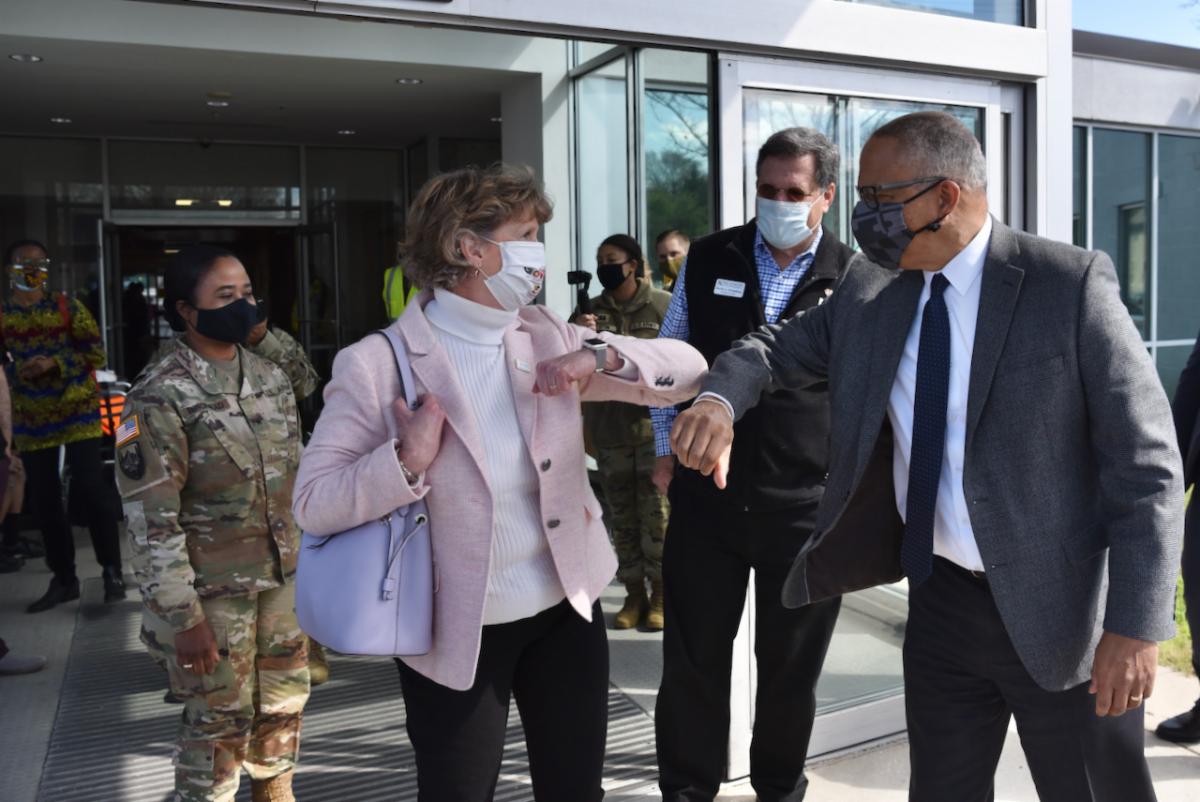 Secretary Beatty bumps elbows with Lt. Governor Rutherford at an entrance to a clinic. 