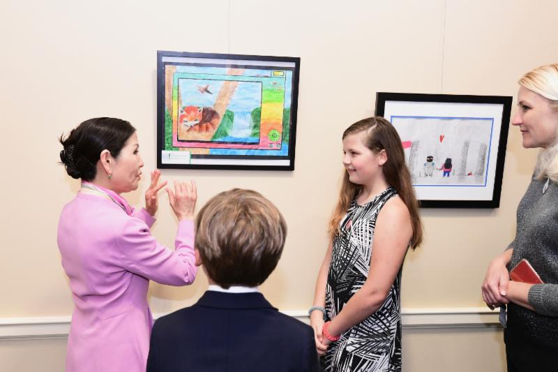 First Lady talks with artist in front of picture. 