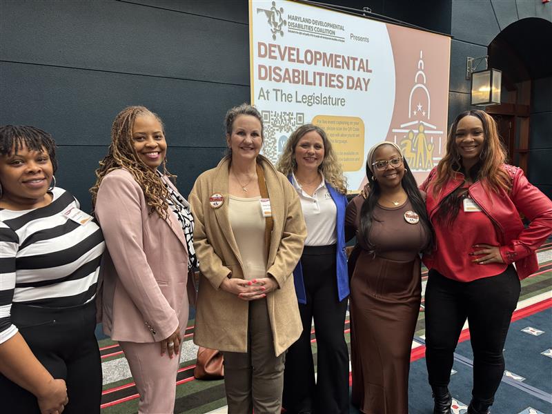 The Coordinating Center's team stands for a photo in front of a banner at Developmental Disabilities Day at the Legislature.