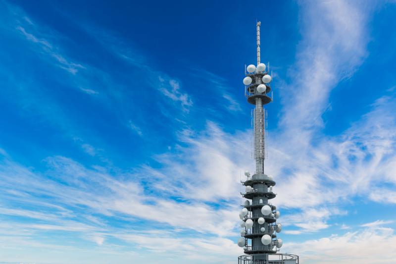 Telecommunications equipment - directional mobile phone antenna dishes. Wireless communication with bright blue sky background.