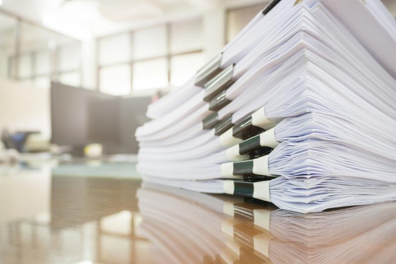 Pile of unfinished documents on office desk. Stack of business paper.