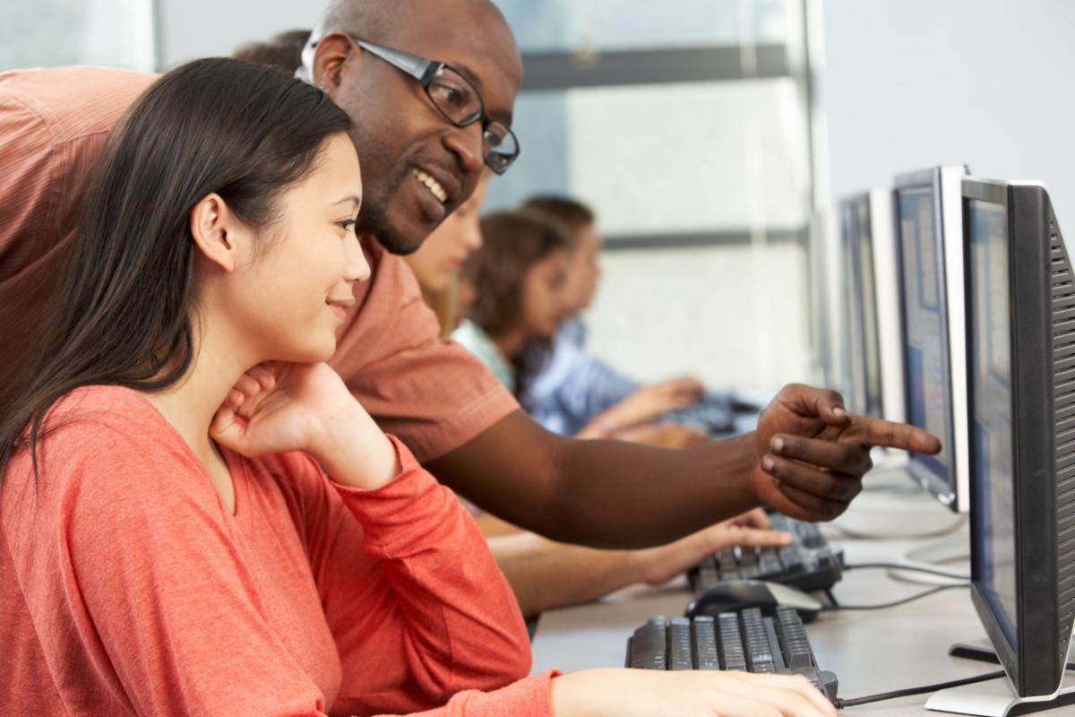 Computer Lab Instructor assisting student on a computer.