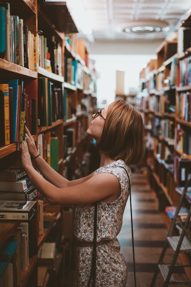 A woman looking at a library shelf