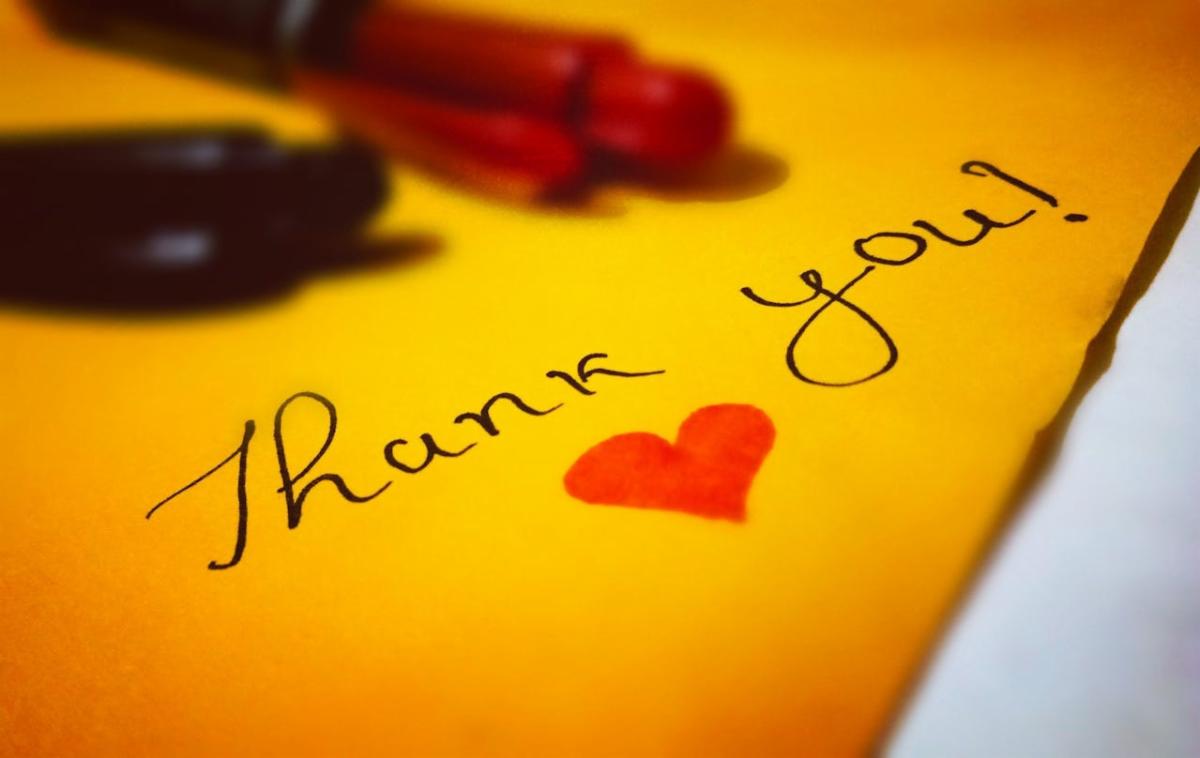 The words Thank you with a red heart on yellow paper