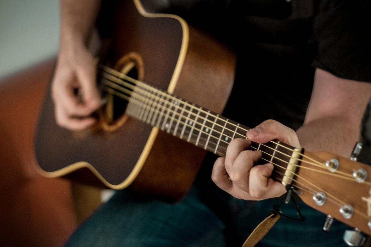 Close-up of a person's hands playing an acoustic guitar