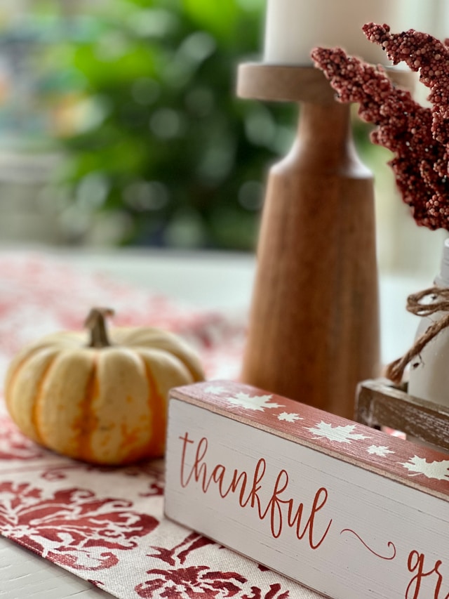 a pumpkin and a sign saying thankful on a table