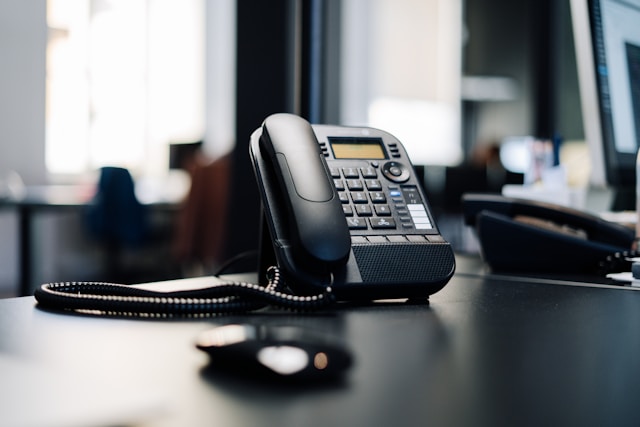 a black business phone on a desk