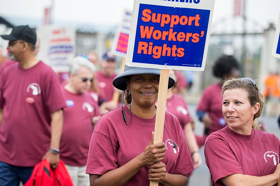 A woman marching on Labor Day 2017 with a sign that says Support Workers' Rights