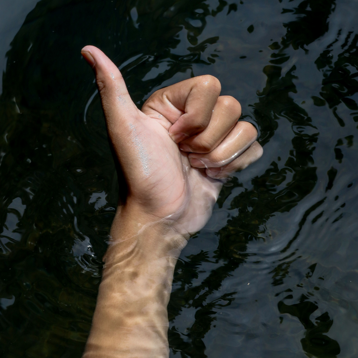 Thumbs up over water