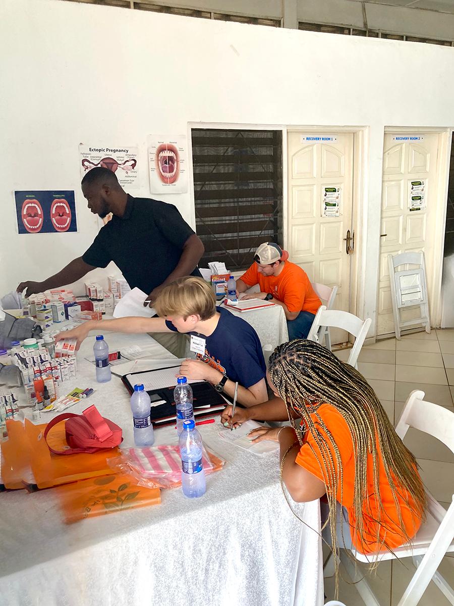 Students setting up pharmacy table at Global Service Learning