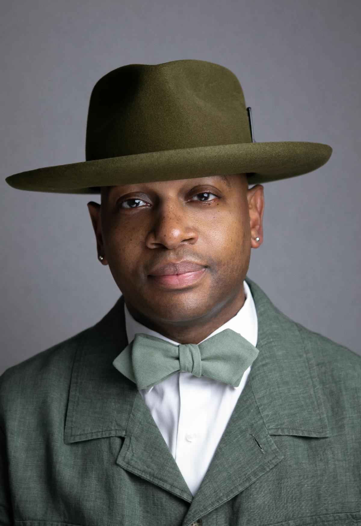 A photograph portrait of a man wearing a hat, bow tie, and suit.