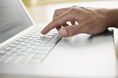 Hand typing on laptop keyboard.