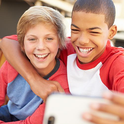 two boys smiling and taking a photo together
