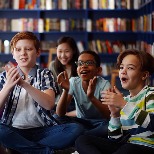 kids in a library smiling