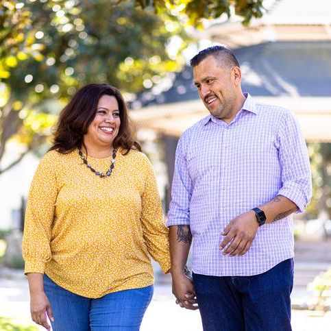 couple walking outside holding hands and smiling