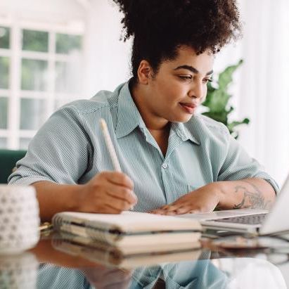 woman sitting on table writing and studying 