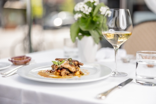 Delicious gourmet meal entree at fancy restaurant on white linen table clth in the summer