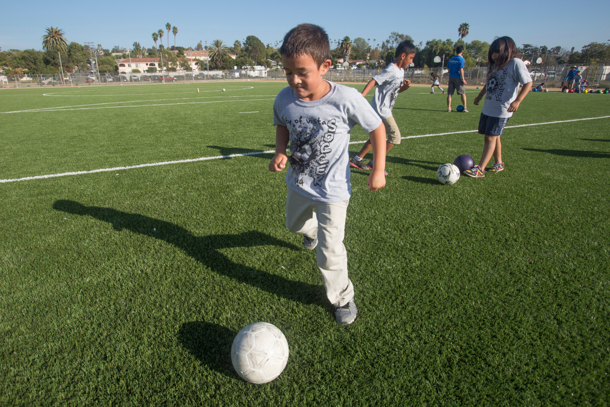Child playing soccer 
youth sports