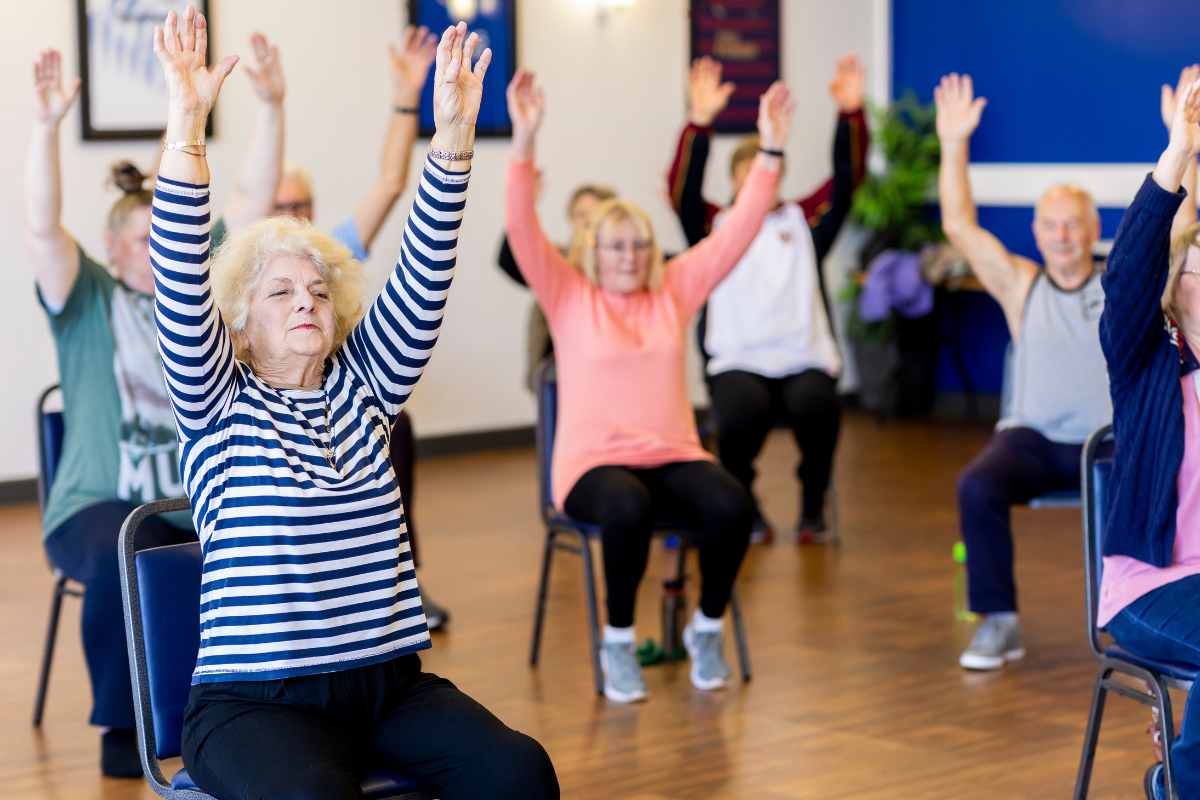 Seniors doing chair yoga.