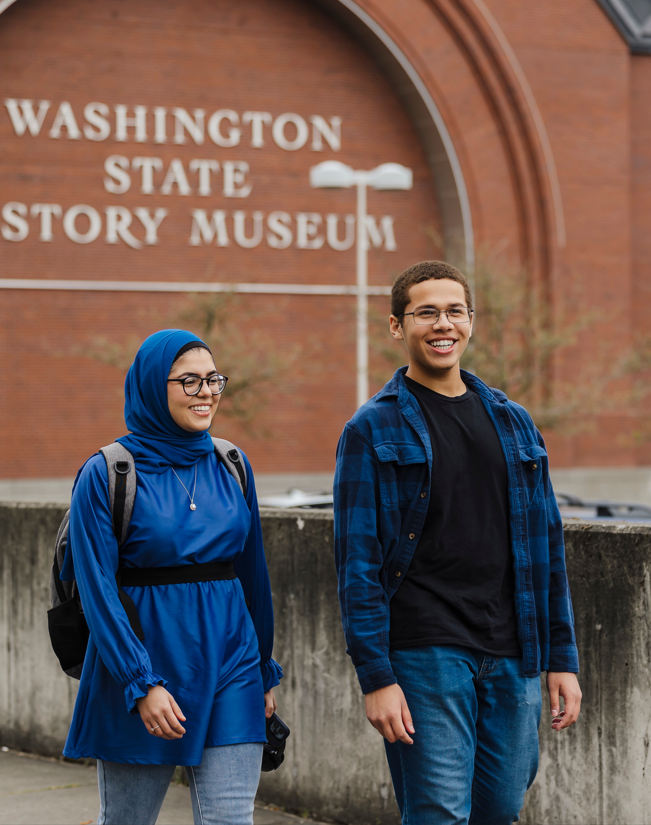 a female and male, both on bikes with helmets on stopped on the Narrows bridge to take a selfie. 