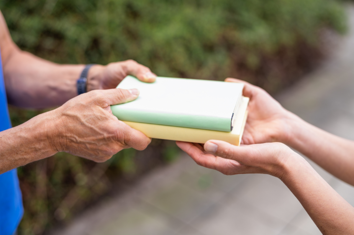 photo of hands passing over a book