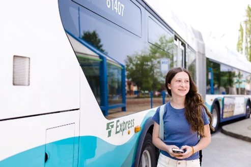 Youth with backpack standing outside  bus