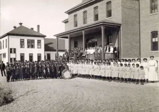 Ute children stand outside one of the assimilation schools in Colorado.