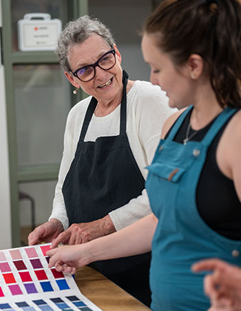 Instructor working with student to pick fabric samples. 