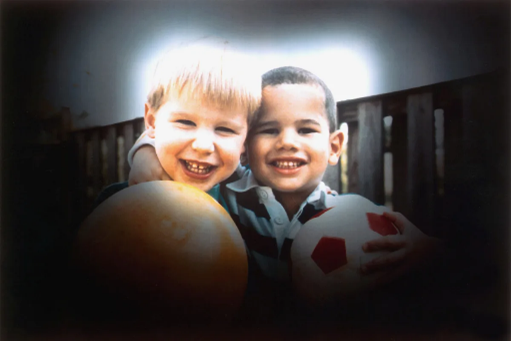 A couple of young boys holding balls. This is a simulation of how a person with glaucoma might see. 