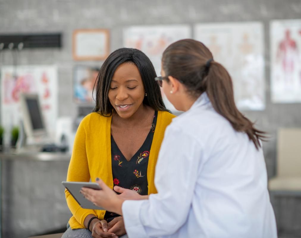 A woman reviewing health information with her health care professional. 