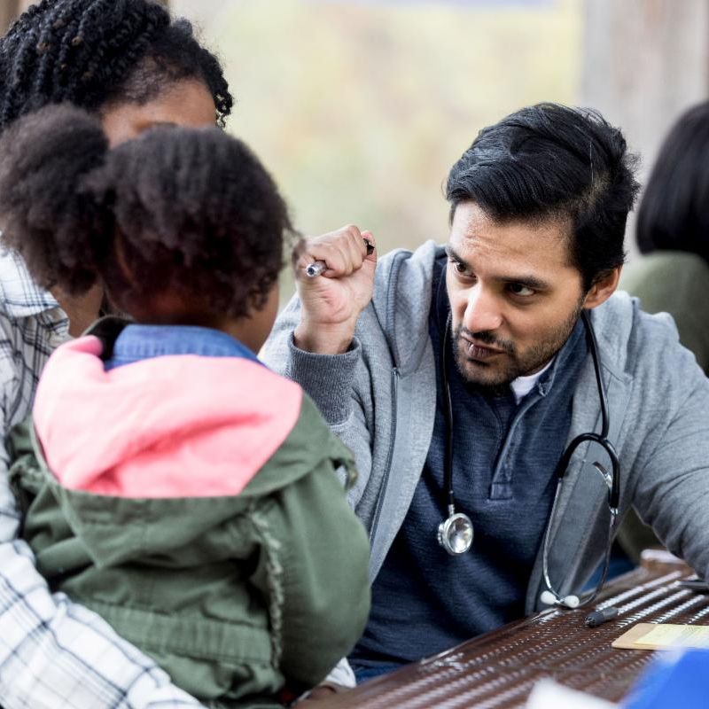 A healthcare provider giving a vision screening to a child.
