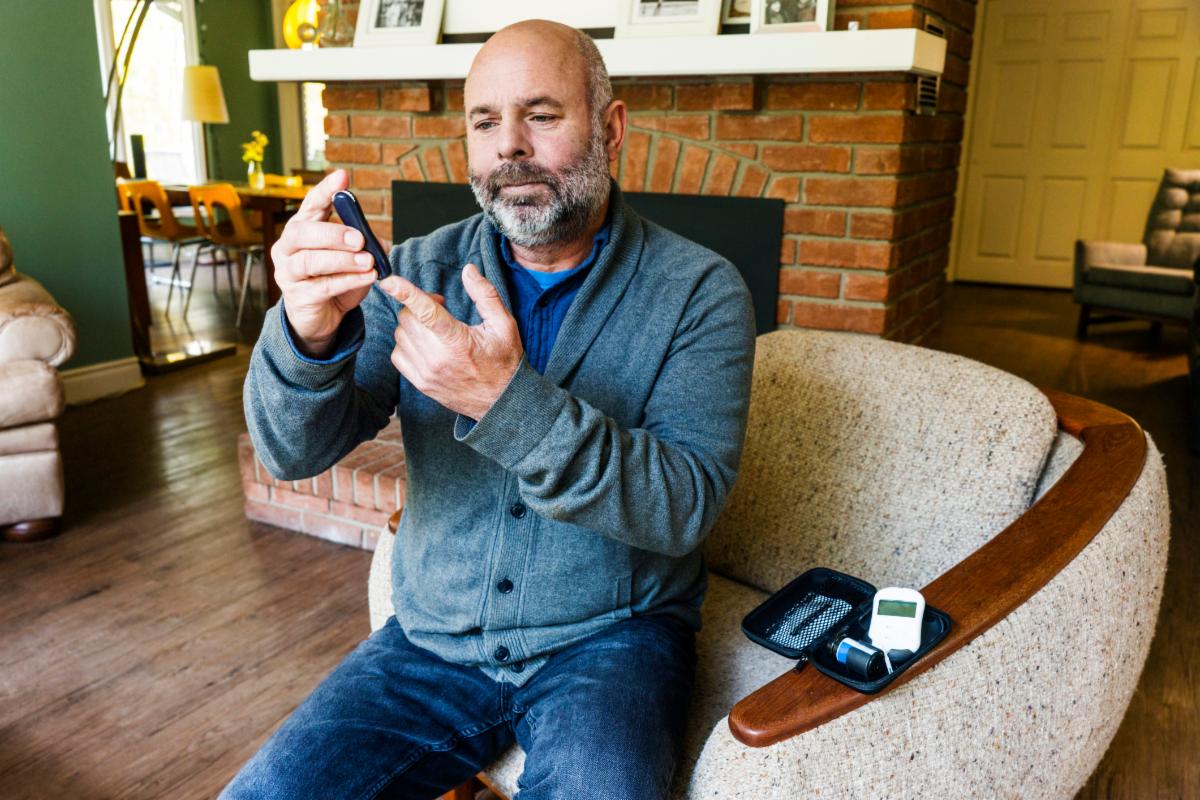 An adult checking their blood sugar at home.