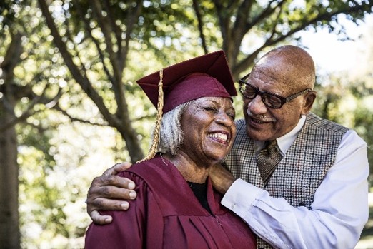 A person hugging a person in a graduation gown