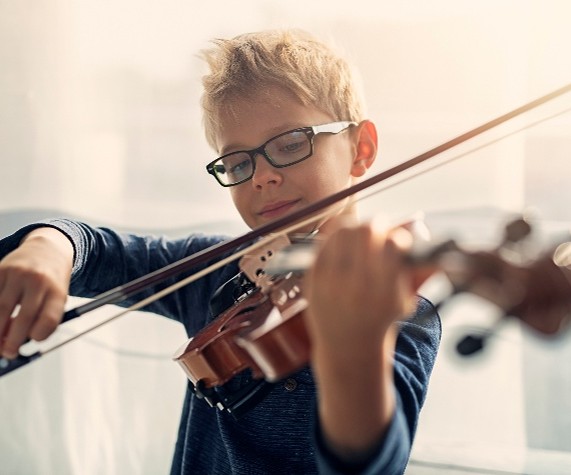 Child holding bow and playing violin