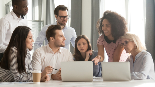 Diverse employees team discussing online project at briefing_ listening to mixed race businesswoman sharing startup ideas_ using laptop at office meeting_ teamwork concept_ horizontal photo