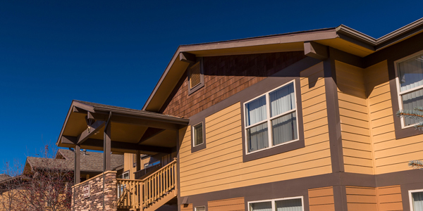A tan multifamily building with deep blue sky