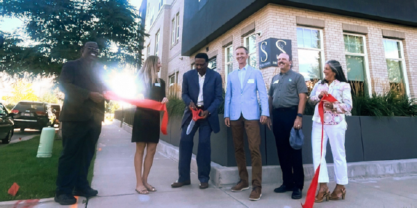 A group of people who just cut a red ribbon at the St Stephens Apartments grand opening in september 2025
