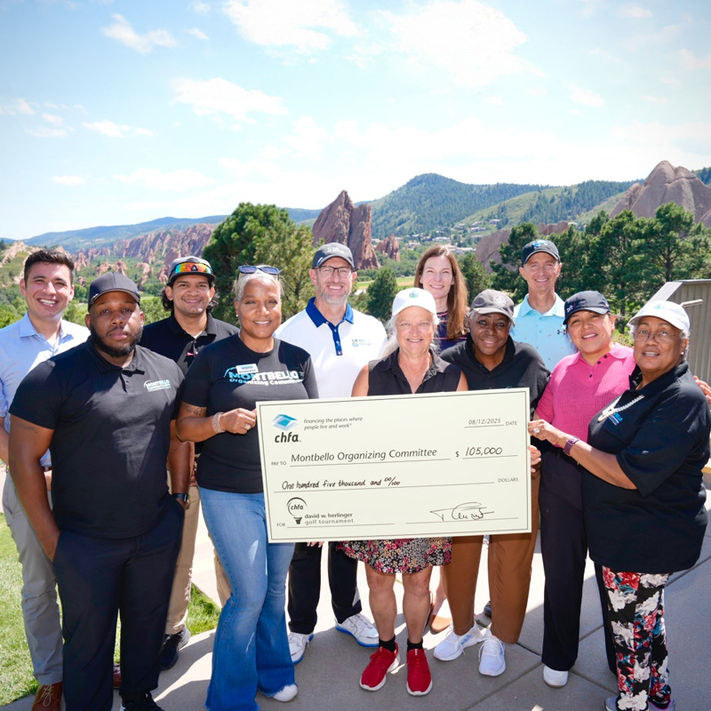 A group of people holding a large check on a golf course