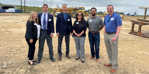 Six people posing for a photo at a groundbreaking