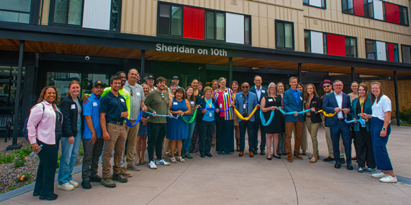 A large group of people posed for a photo in front of a colorful building