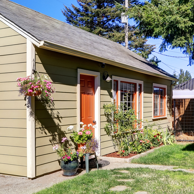 A person holding out their hand to show the word HOME on the wall behind them