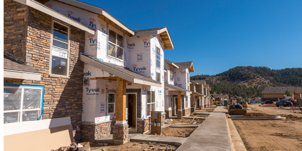 A multifamily building in front of foothills. 