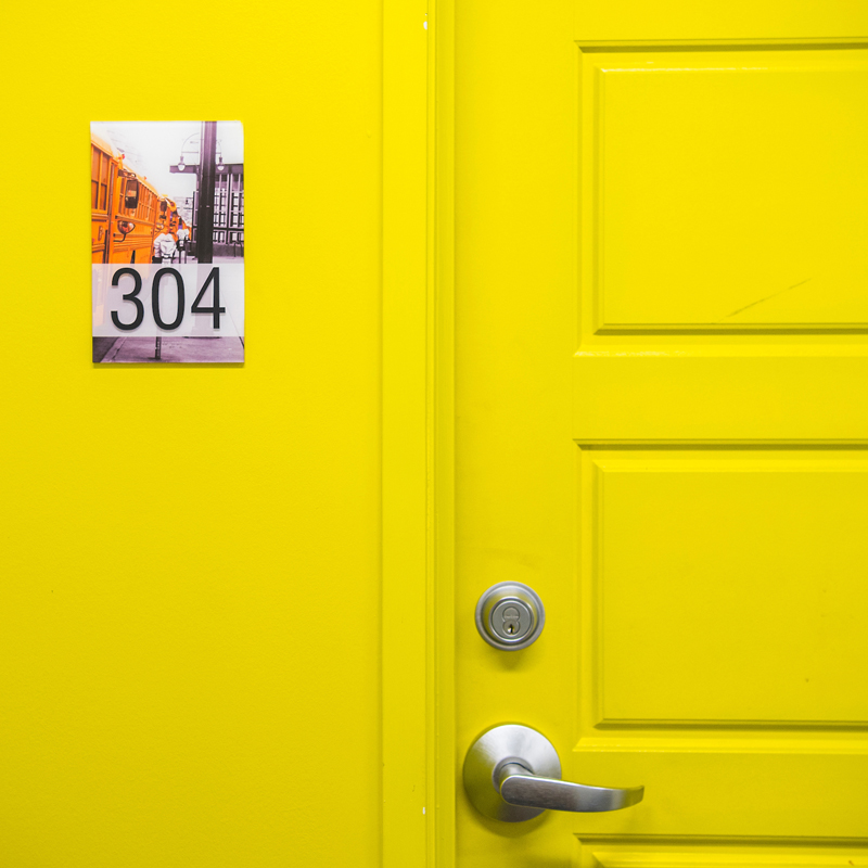 partial view of a yellow door with a number plate that says 304
