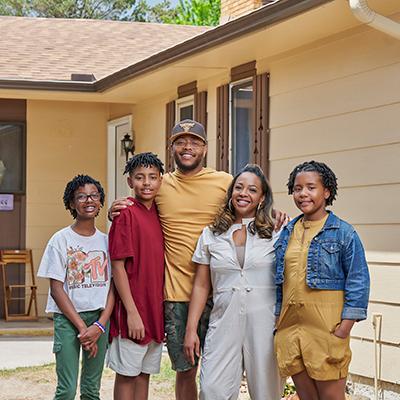 A family standing in front of their home