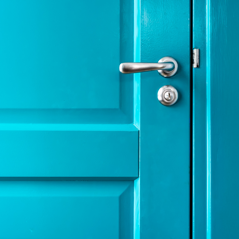 a teal door with a silver handle