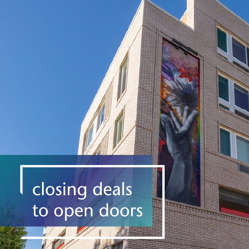 A multifamily building with blue sky and text that reads closing deals to open doors